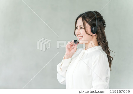 A woman wearing a headset for call center, operator, teleoperation, teleappointment, user support A woman wearing a headset for call center, operator, teleoperation, teleappointment, user support 119167069