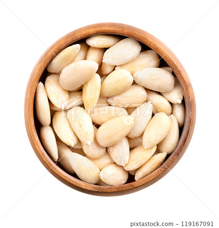Freshly blanched almonds in a wooden bowl. Shelled almonds that have been treated with hot water to soften the seed coat, which is then removed to reveal the white seed. Fruits of Prunus amygdalus. Freshly blanched almonds in a wooden bowl. Shelled almonds that have been treated with hot water to soften the seed coat, which is then removed to reveal the white seed. Fruits of Prunus amygdalus. 119167091