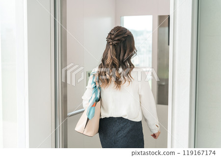 Business woman getting on an elevator 119167174