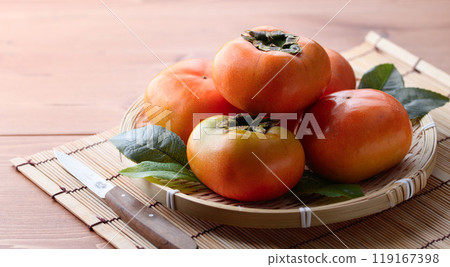 Autumn taste: Persimmons arranged in a basket (wooden background) Persimmon fruit Persimmon Fruit 119167398