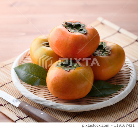 Autumn taste: Persimmons arranged in a basket (wooden background) Persimmon fruit Persimmon Fruit 119167421