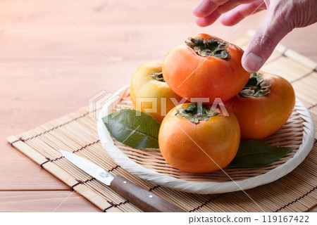 Autumn taste: Persimmons arranged in a basket (wooden background) Persimmon fruit Persimmon Fruit Autumn taste: Persimmons arranged in a basket (wooden background) Persimmon fruit Persimmon Fruit 119167422