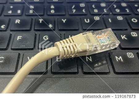 Ethernet Cable Connected to a Laptop Keyboard. 119167873