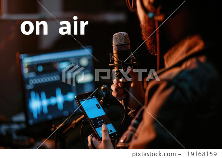 Studio streaming setup: a blogger livestreamer utilizing phone, podcast microphone for online streaming, reviewing business content, promoting through live broadcasts, enhancing digital presence. Studio streaming setup: a blogger livestreamer utilizing phone, podcast microphone for online streaming, reviewing business content, promoting through live broadcasts, enhancing digital presence. 119168159
