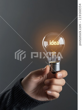 Bright inspiration: hand holding glowing light bulb with text idea symbolizing a moment of creativity, innovative thinking, perfect for presentations or materials focusing on concepts and solutions. 119168354