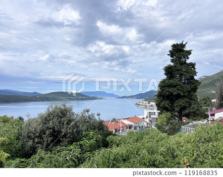 the town of Neum in Bosnia-Herz, its maritime nature and its vegetation. Stroll or walk along the Adriatic Sea, under trees allowing more or less rays of Sun to pass through, in the shade. the town of Neum in Bosnia-Herz, its maritime nature and its vegetation. Stroll or walk along the Adriatic Sea, under trees allowing more or less rays of Sun to pass through, in the shade. 119168835