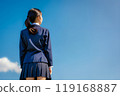 藍天背景下，一個穿著校服的女孩的後視圖。 119168887