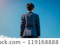 藍天背景下，一個穿著校服的男孩的後視圖。 119168888