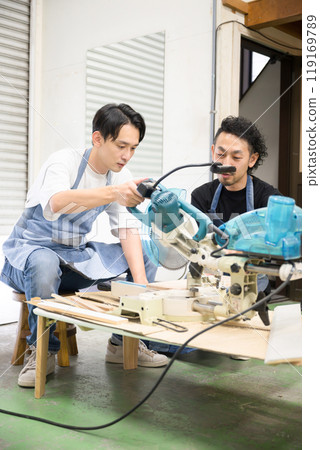 Two male craftsmen doing DIY, cutting wood, crafting and carving - Image of a carpenter or woodworker Two male craftsmen doing DIY, cutting wood, crafting and carving - Image of a carpenter or woodworker 119169789