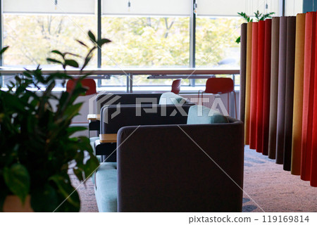 Cozy seating area with colorful fabric dividers and large windows in a modern office during daylight 119169814
