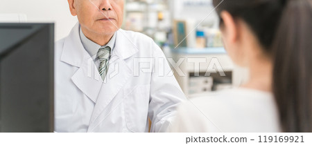 A woman and a pharmacist who consult about medicines and prescriptions at a pharmacy / drug store A woman and a pharmacist who consult about medicines and prescriptions at a pharmacy / drug store 119169921
