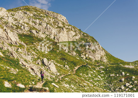 Young Woman Hiking Alone in Summer Mountains Young Woman Hiking Alone in Summer Mountains 119171001