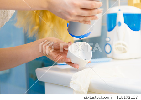 Woman pouring purple hair dye or shampoo 119172118