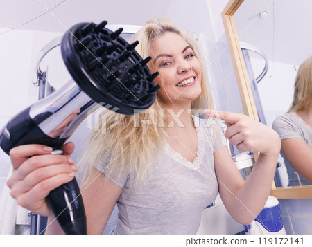 Woman doing curls with hairdryer diffuser 119172141