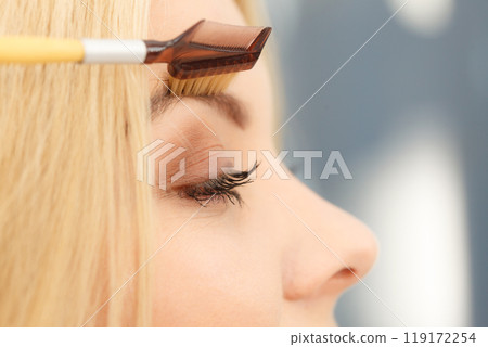 Woman brushing her eyebrows 119172254