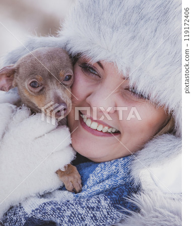 Woman playing with dog during winter Woman playing with dog during winter 119172406