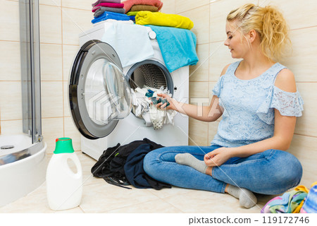 Woman wash laundry using detergent pods 119172746