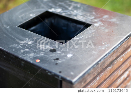 A wooden trash can containing a black garbage bag inside it A wooden trash can containing a black garbage bag inside it 119173643