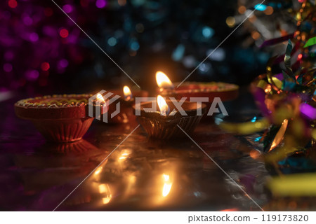 Diwali celebration background with glowing clay lamps and colorful lights. Diwali celebration background with glowing clay lamps and colorful lights. 119173820
