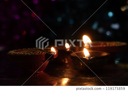 Traditional Diwali diyas with bokeh effects on dark background Traditional Diwali diyas with bokeh effects on dark background 119173859