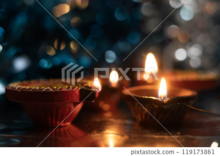 Diwali diyas (oil lamps) lit up with a background of colorful bokeh effects. Diwali diyas (oil lamps) lit up with a background of colorful bokeh effects. 119173861