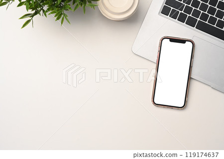 Mobile phone with blank screen, laptop, and paper cup of coffee on white table Mobile phone with blank screen, laptop, and paper cup of coffee on white table 119174637