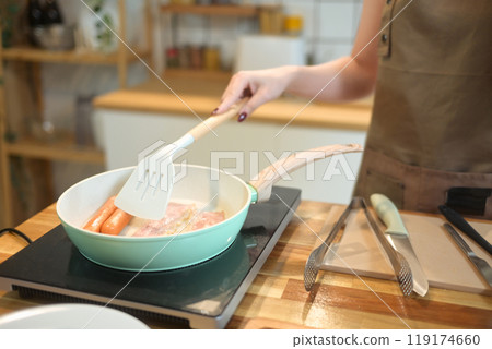 Cropped shot of young woman preparing breakfast in her kitchen 119174660