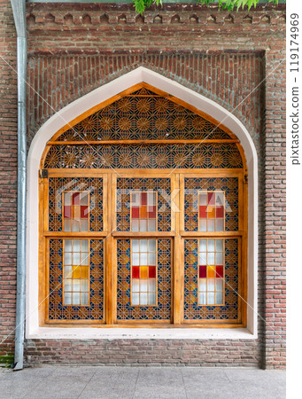 Architectural magnificence of a window at Juma Mosque in Ganja, Azerbaijan, featuring intricate stained glass designs 119174969