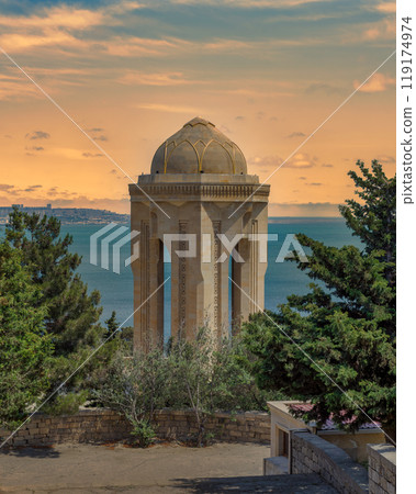 Eternal Flame Monument in Baku, Azerbaijan stands tall against a backdrop of a colorful sunset sky 119174974