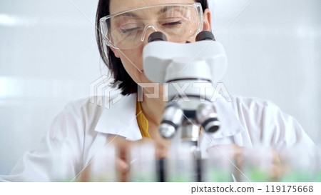 Woman scientist using microscope in laboratory. Microbiology science concept 119175668