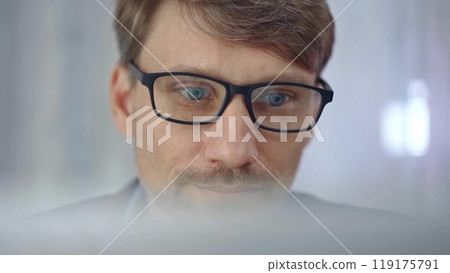 Businessman with glasses looking intently obscured partially by a translucent surface of laptop. Business people concept 119175791