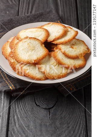 Almond tuiles a French cookie with allure closeup on the plate. Vertical Almond tuiles a French cookie with allure closeup on the plate. Vertical 119177147