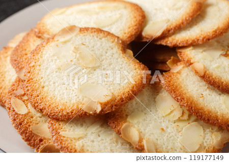 French delicacy pastry tuile with almond closeup on the plate. Horizontal French delicacy pastry tuile with almond closeup on the plate. Horizontal 119177149