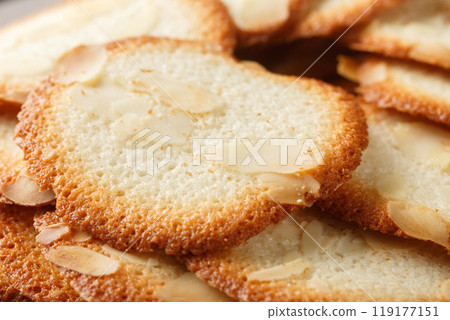 Almond tuiles Tejas de almendras, roof tile shaped almond pastry closeup on the plate. Horizontal 119177151
