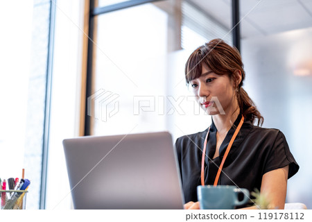A woman working on a computer with a serious expression 119178112