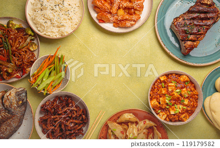 Assorted traditional chinese dishes top view on green background: kung pal chicken, sweet and sour pork, noodles, dumplings, mapo tofu, fish, rice with copy space 119179582