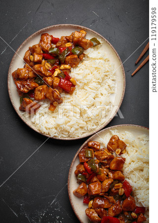 Kung pao chicken with peanuts and rice on a two plates top view, traditional Chinese cuisine Kung pao chicken with peanuts and rice on a two plates top view, traditional Chinese cuisine 119179598