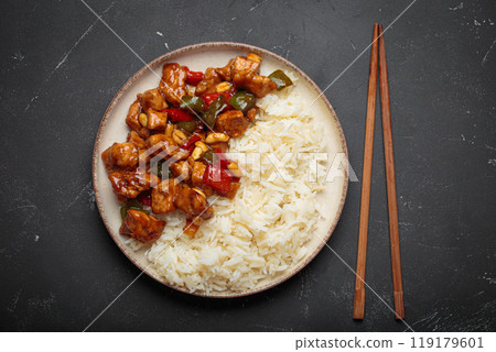 Kung pao chicken with peanuts and rice on a plate top view, traditional Chinese cuisine Kung pao chicken with peanuts and rice on a plate top view, traditional Chinese cuisine 119179601