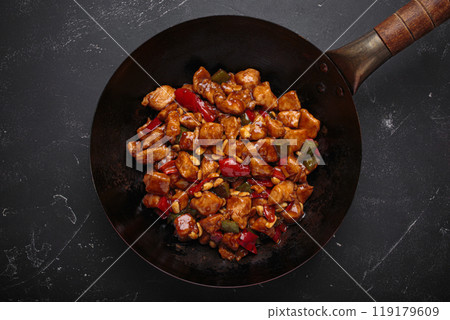 Traditional Chinese dish kung pao chicken in wok pan on dark background top view Traditional Chinese dish kung pao chicken in wok pan on dark background top view 119179609