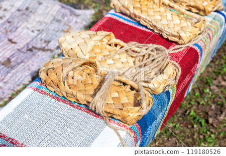 Wicker bast shoes on the vintage homespun doormat Wicker bast shoes on the vintage homespun doormat 119180526