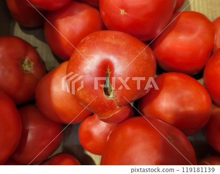 A red ugly tomato is lying with others on the store counter. A red ugly tomato is lying with others on the store counter. 119181139