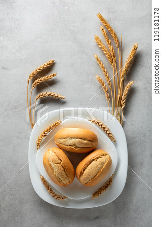 French buns and wheat ears on a marmoreal table. French buns and wheat ears on a marmoreal table. 119181178