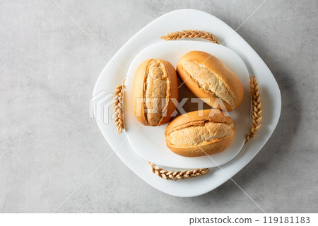 French buns and wheat ears on a marmoreal table. French buns and wheat ears on a marmoreal table. 119181183