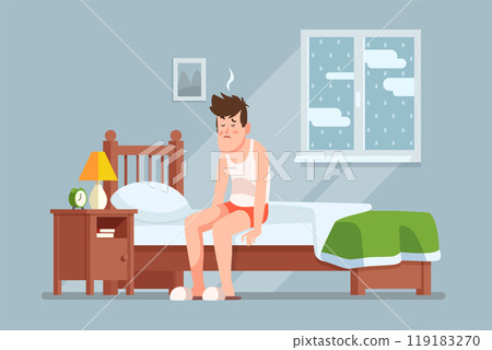 Man sitting on bed looking unwell in a cozy bedroom setting during a rainy morning 119183270