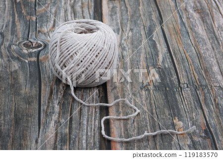 Ball of string on wood 119183570
