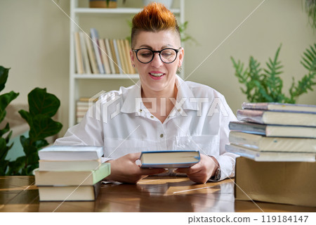 Woman with new books unpacked from cardboard box Woman with new books unpacked from cardboard box 119184147
