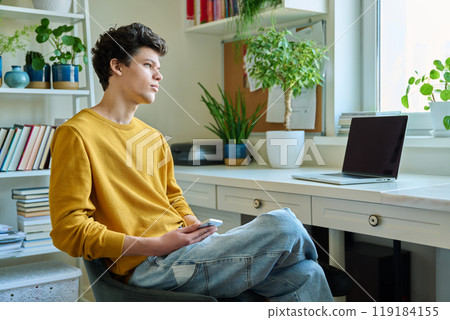 Young handsome guy using smartphone sitting, at home 119184155
