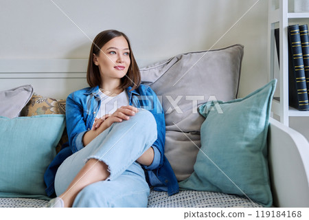 Relaxed young beautiful happy woman sitting on couch at home Relaxed young beautiful happy woman sitting on couch at home 119184168