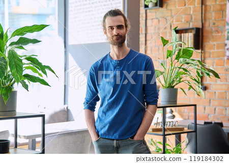 Portrait of young confident handsome man looking at camera 119184302