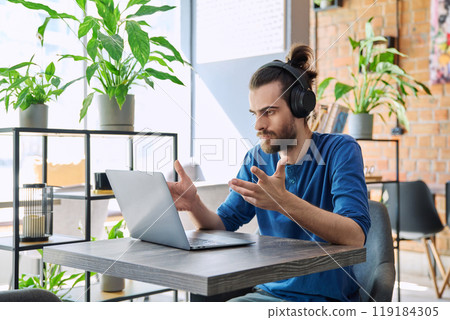 Young handsome man in headphones having work video chat using laptop 119184305